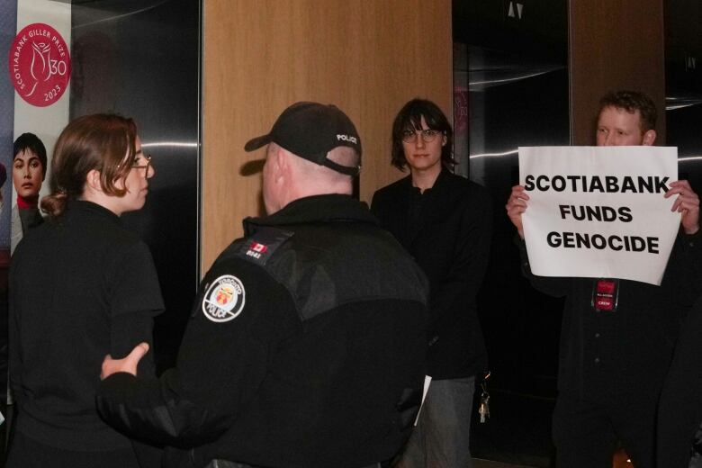 Protesters are escorted out of the Four Seasons Hotel by the Police after interrupting the Scotiabank Giller Prize ceremony in Toronto, on Monday, November 13, 2023.