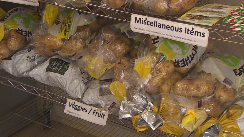 A shelf inside a building is full of bags of potatoes.