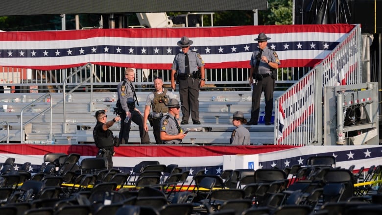 Law enforcement father on an empty bleacher at an outdoor event.