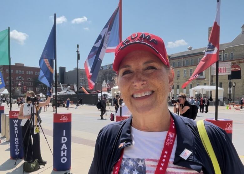 A woman wearing a red hat with the word TRUMP on it.