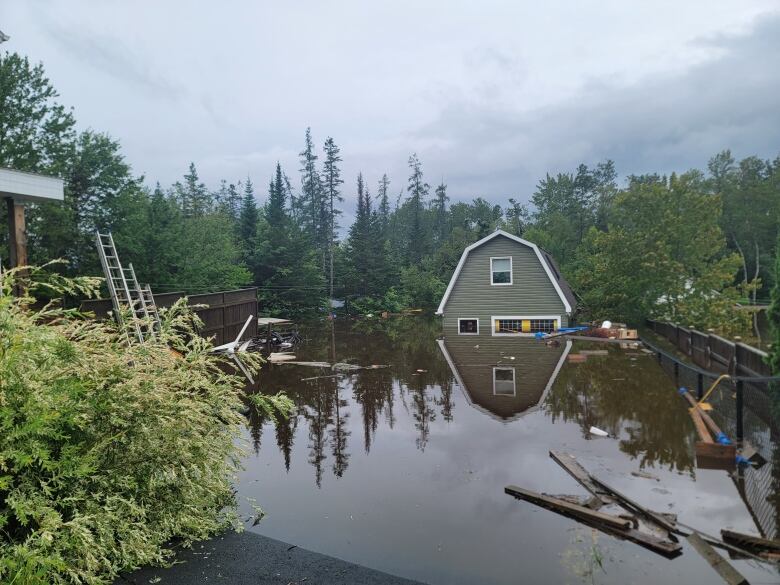 a garage is underwtaer and surroiunded by floating debris 