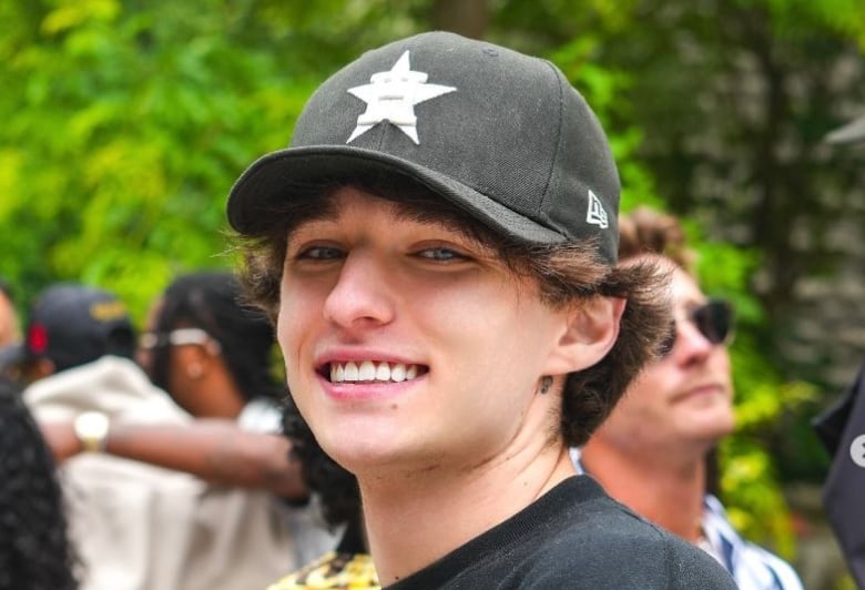 Man in baseball cap smiling.