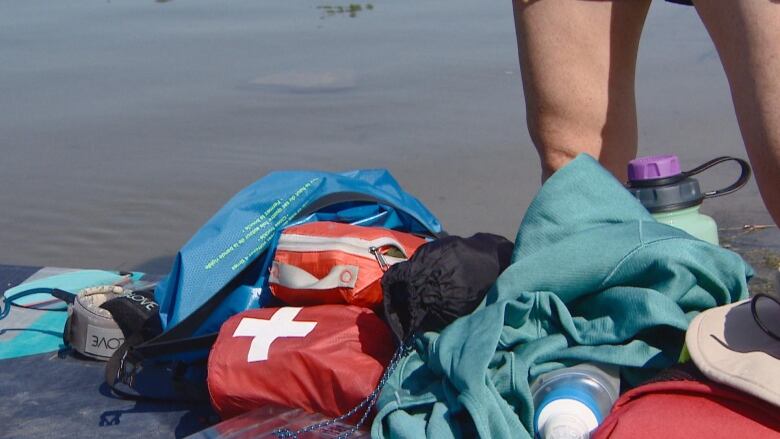 Rebecca Mollison, a volunteer with Saskatoon Search and Rescue, diswplayed some of the items in her safety bag before she went paddleboarding this week. It iuncluded a first aid kit, water and a water pump, a sun hat and other items.