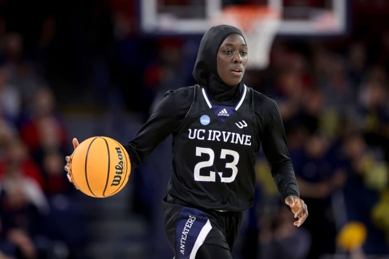 A woman basketball player wears a hijab.