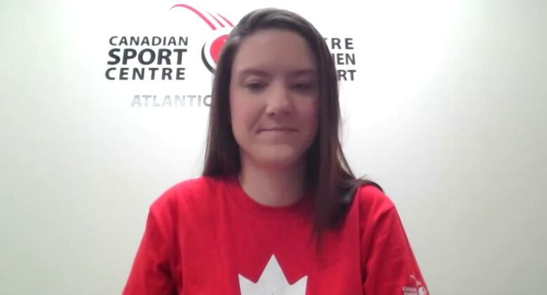 A woman with long hair wearing a red t-shirt