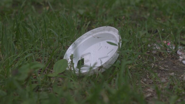 A Tim Hortons coffee cup lid is visible here in the grass.