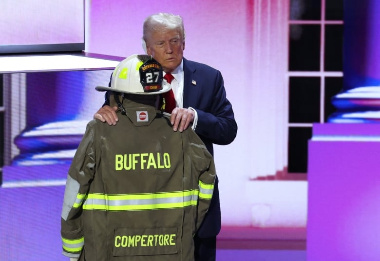 Trump embraces the firefighter's coat and helmet of Corey Comperatore, who was killed at his rally Saturday.