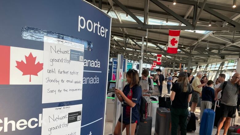 A sign with people waiting at an airport.