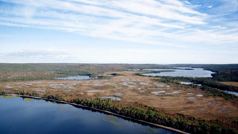 an aerial view of land near water.