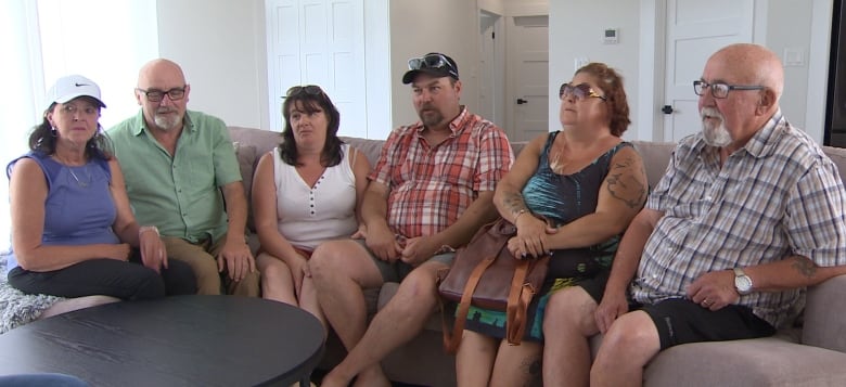 Image of living room with people sitting on couch.