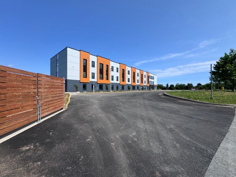 A rectangular building near a parking lot. 