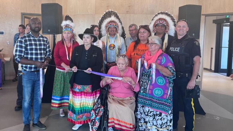 A group of people gathered for a photo and ribbon cutting at the opening of a new community centre