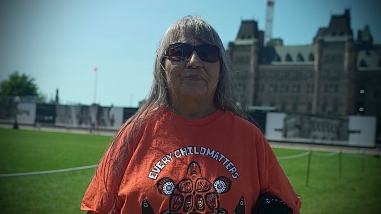 Sherlene Bomberry, a woman, stands facing the camera.