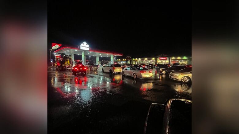 Cars wait in line to fill up at a gas station in Valemount, B.C., after people flee Jasper, Alta., due to wildfires on July 23, 2024.