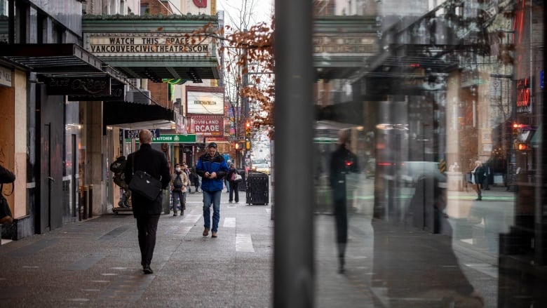 People walk on a busy downtown street in the entertainment district.