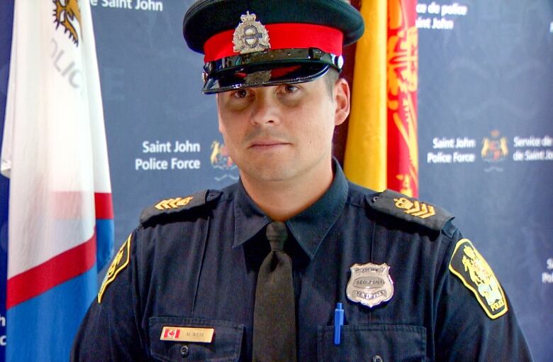 Man in police officer uniform looking at camera with a neutral expression.