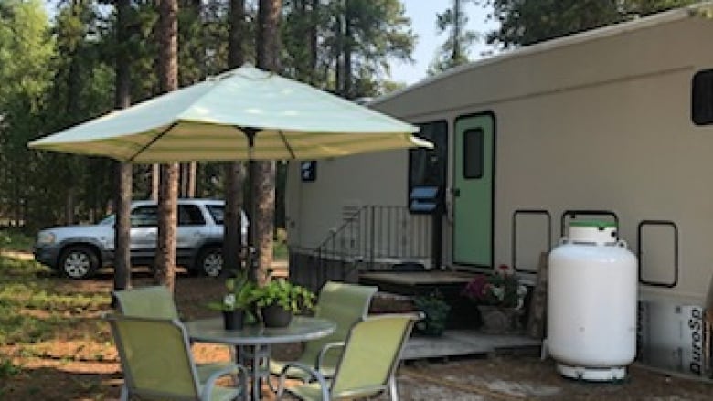 An RV is pictured beside a patio table and chairs