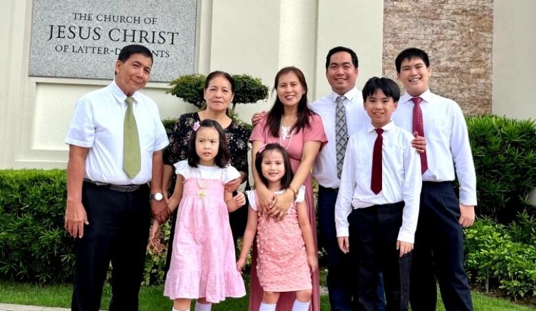 people stand outside of church building in formal attire