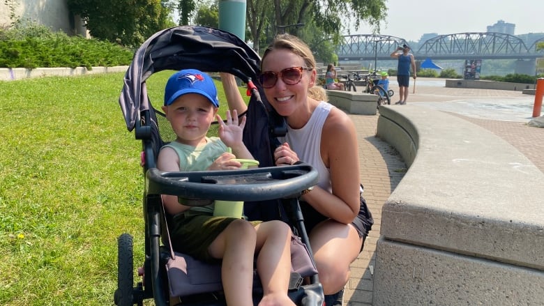 Lindsay McDowell and her son Sutter, 3, enjoy some time by the river in Saskatoon while navigating a summer of air quality advisories and drifting wildfire smoke. 