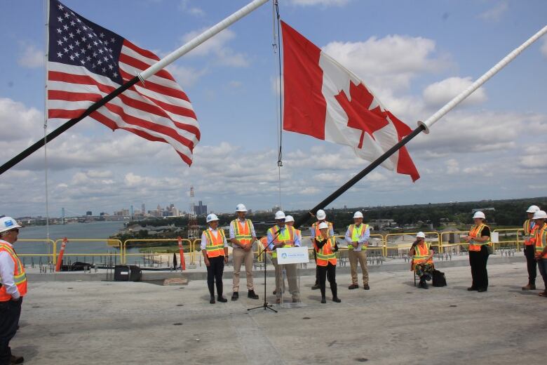 A group of people wearing safety gear on a bridge standing near a podium.