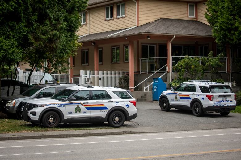 Multiple police cruisers are pictured outside a house.