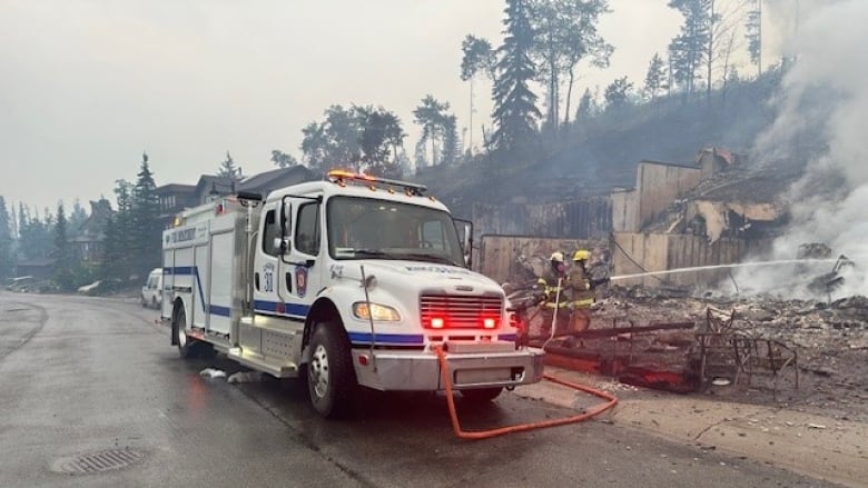 Firefighters are pictured spraying structure during wildfires that entered Jasper, Alta.