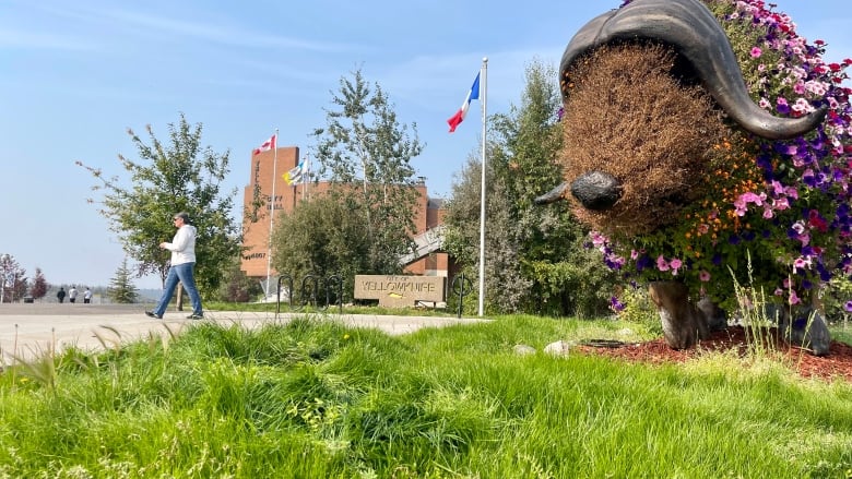 A statue of a bison with flowers on it.