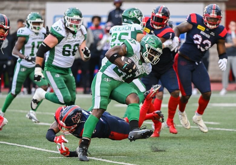 Saskatchewan Roughriders running back Frankie Hickson (20) evades a tackle during first half CFL football action against the Montreal Alouettes in Montreal, Thursday, July 25, 2024. 