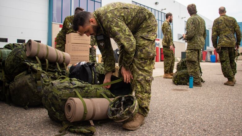 A soldier places a military backpack.