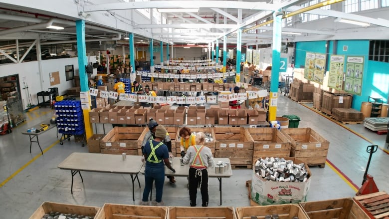 Aerial (drone) images of the Daily Bread Food Bank warehouse and distribution centre in Etobicoke. Volunteers sorting goods in a large warehouse full of cardboard boxes