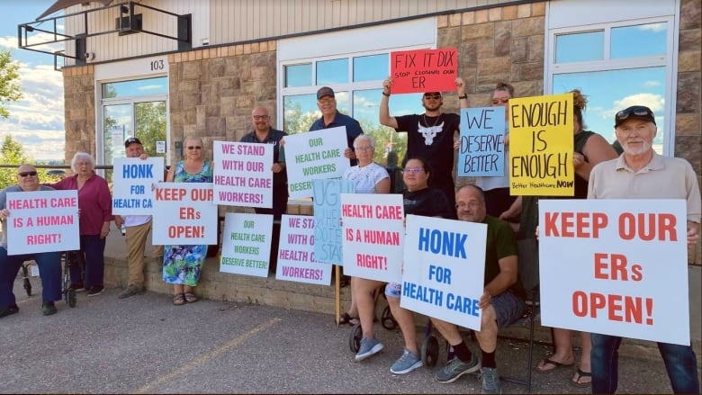 People hold up signs supporting health-care workers at a rally.