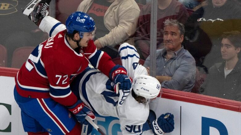 Toronto Maple Leafs' Max Ellis (90) is checked into the boards by Montreal Canadiens' Arber Xhekaj (72) during first period NHL preseason hockey action in Montreal on Friday, Sept. 29, 2023. 