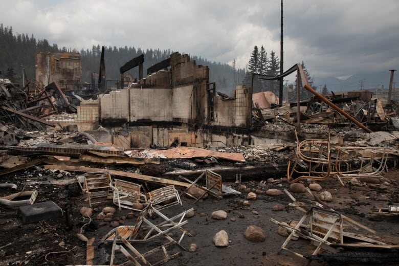 Burned rubble and chairs litter the ground.