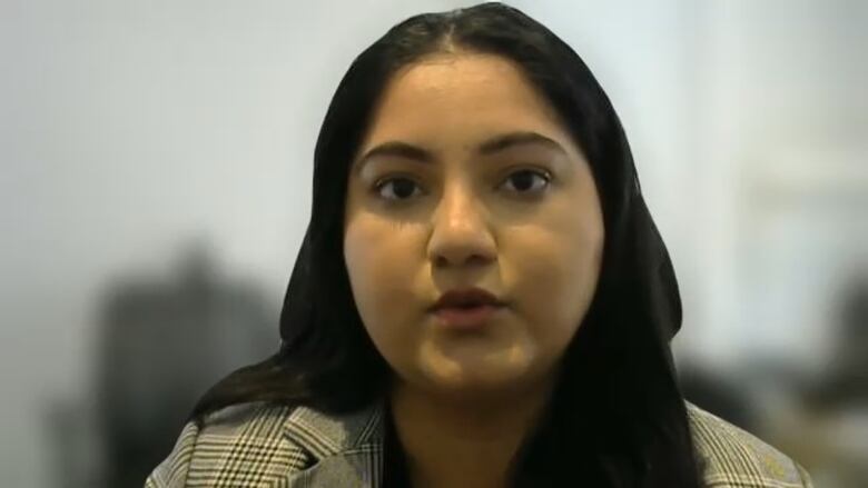 A headshot of a woman wearing a striped blazer, taken from a Zoom call. The woman is of South Asian origin.