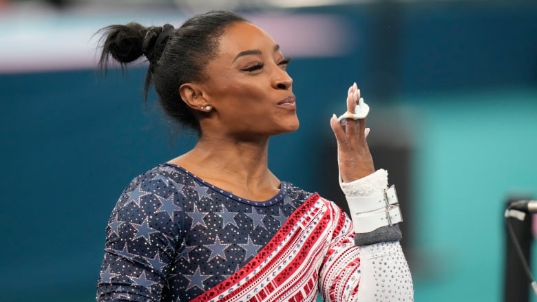 Simone Biles, of the United States, performs on the uneven bars during the women's artistic gymnastics team finals round at Bercy Arena at the 2024 Summer Olympics, Tuesday, July 30, 2024, in Paris, France.