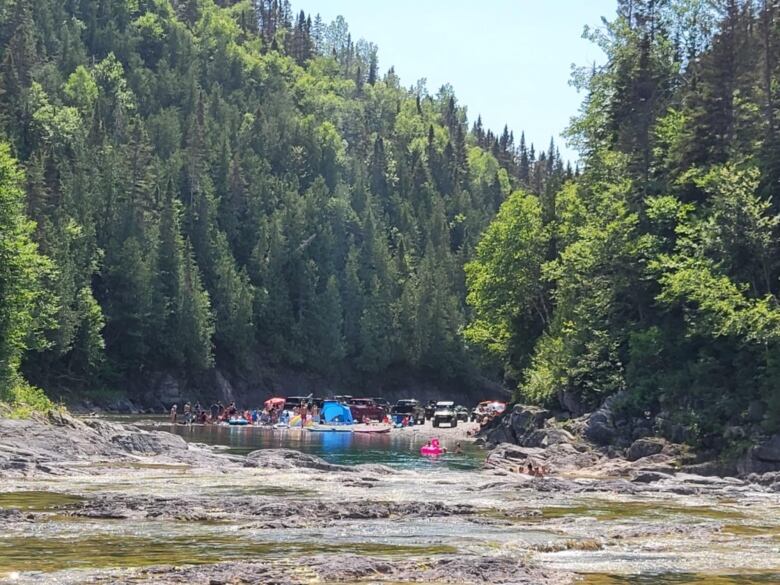 Car are seen in the distance next to a river