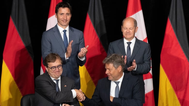 Canadian Prime Minister Justin Trudeau and  German Chancellor Olaf Scholz applaud as Natural Resources Minister Jonathan Wilkinson and German vice-chancellor Robert Habeck shake hands after signing an agreement, Tuesday, August 23, 2022 in Stephenville, Newfoundland and Labrador.  THE CANADIAN PRESS/Adrian Wyld