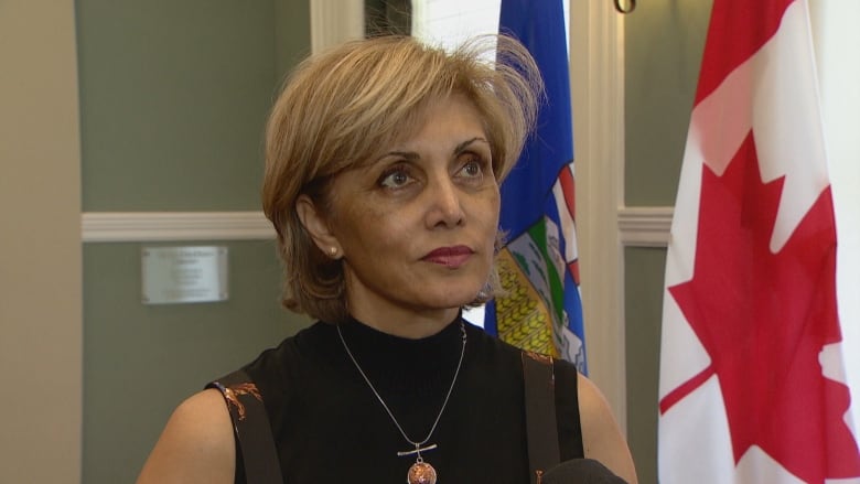 A woman answers questions from a reporter.