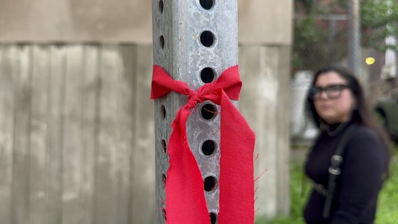 A red piece of cotton is tied around a post.