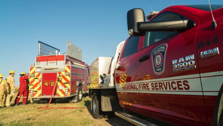 A fire crew checks equipment on a truck. 