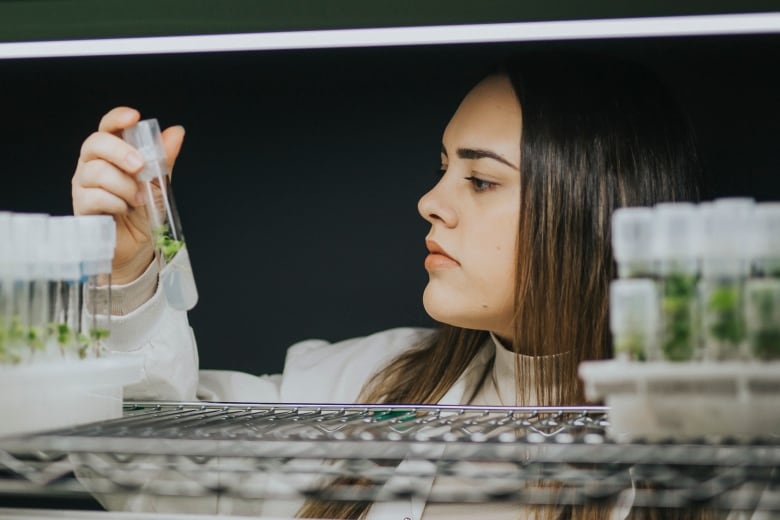 Woman holding a vial in a lab. 