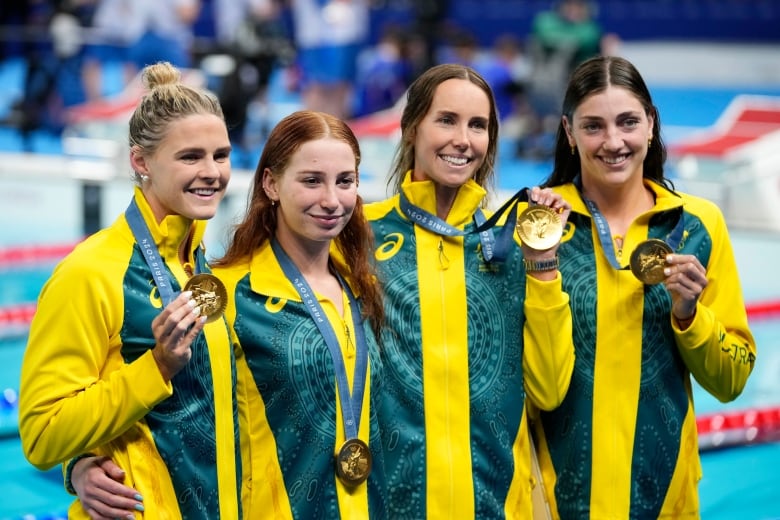 Four women hold up Olympic medals