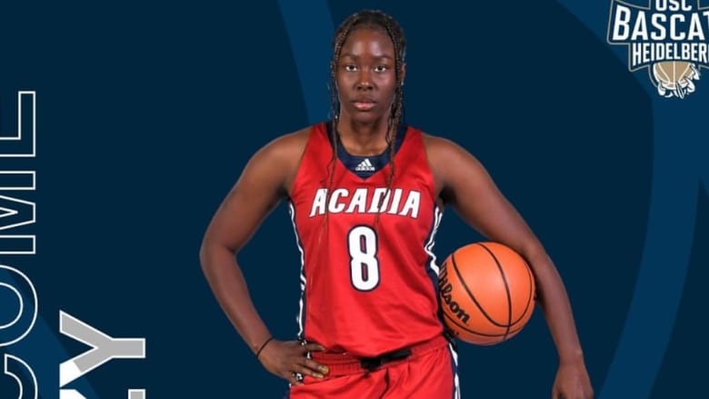 Woman poses with a basket ball wearing red shorts and a red jersey.