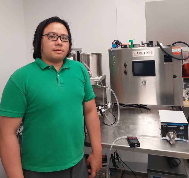 A man standing next to a membrane water purification system.