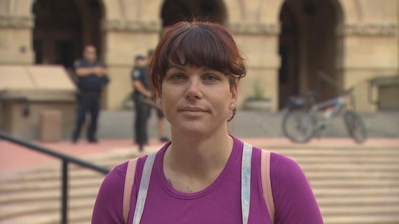 A close-up shot of a woman in a colorful t-shirt. She is seen sporting a fringe and smiling at the camera.