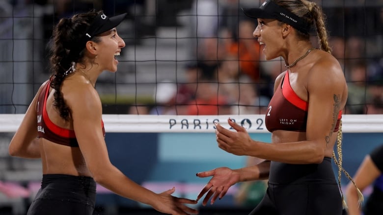 A pair of women's volleyball players celebrate with each other