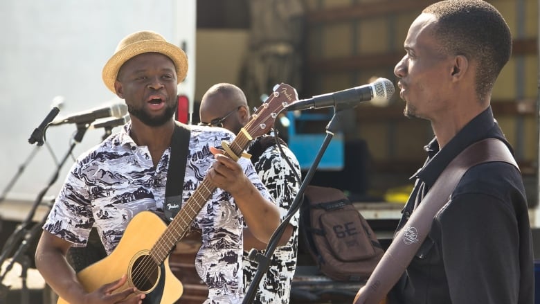 Two men with guitars on stage singing