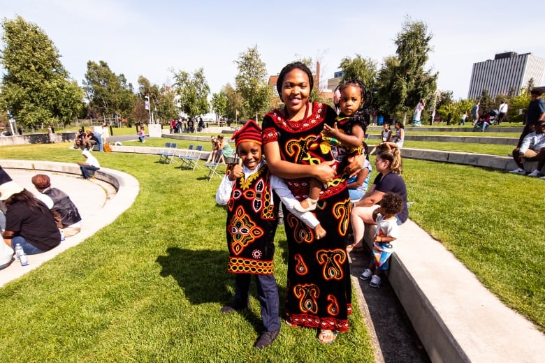 Mother and son in traditional embroidered tunics with the colours of the Cameroon flag