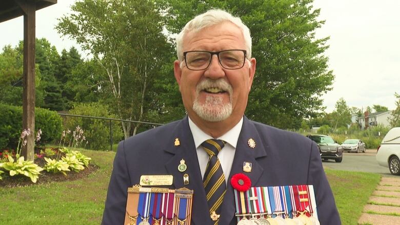 Man in military uniform wearing poppy and medals.