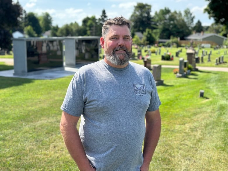 A man stands in a cemetery.